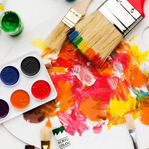 Paint palette and paint brushes with colorful brush strokes