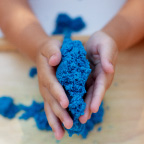 a child's hands playing with sand