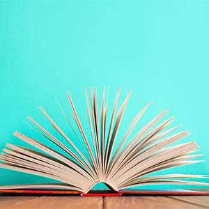 An open hardcover book on a teal background