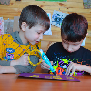 Two children using a 3d pen