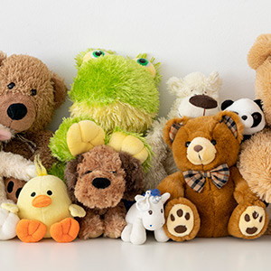A collection of stuffed animals, including a frog, bears, unicorn, and duck