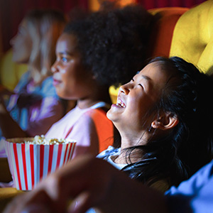 Child laughing while watching movie in darkened theater