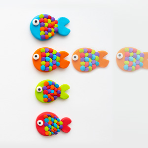 4 colorful clay fish in a row. Transparent duplicate fish suggest motion.