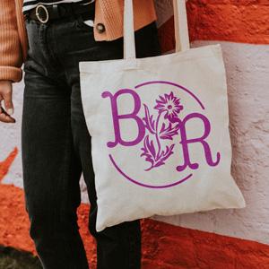 Person holding totebag decorated with a "BR" monogram