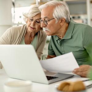 Senior couple looking at documents on computer