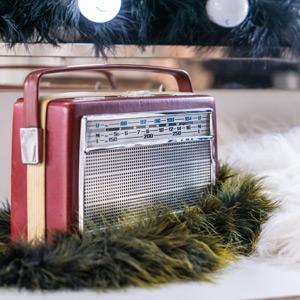 Red vintage radio surrounded by cozy fur and evergreens