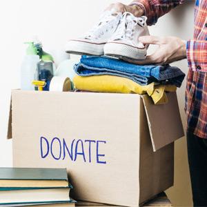 Placing shoes into box labeled "donate"