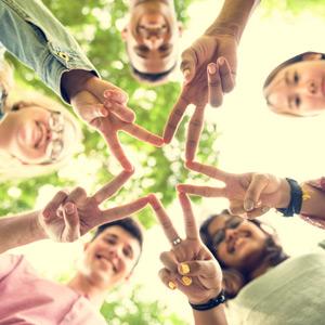 Teens holding fingers together to form a star