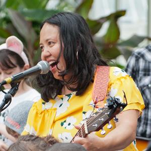 Little Miss Ann playing a string instrument and singing