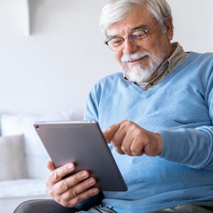 Smiling senior man using ipad