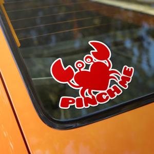 A heart-shaped crab decal on a car window